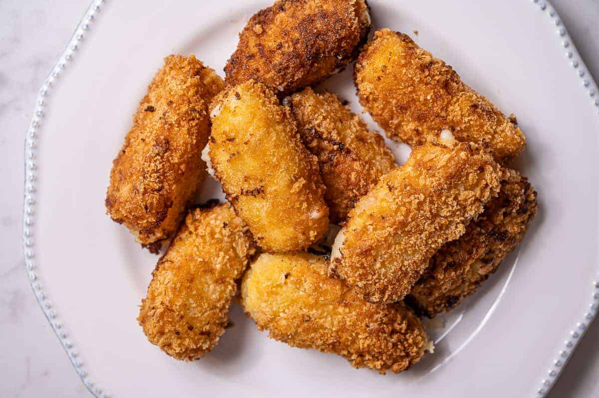 Overhead view of a plate of fried Serrano ham croquettes.