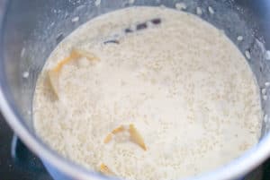 Arroz con leche cooking in a large metal pot.