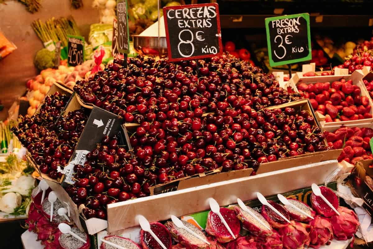 Boxes full of dark red cherries at a market stall.