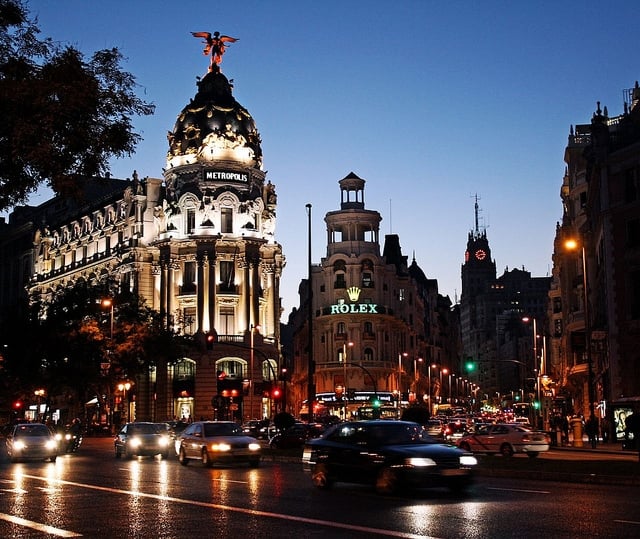 The busy street of Gran Vía, with its ornate buildings lit up at night.