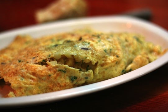 Close-up of a Spanish potato omelet with bits of green veggies mixed in.