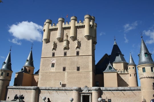 Segovia's medieval castle from the outside, with several turrets and a large square tower.