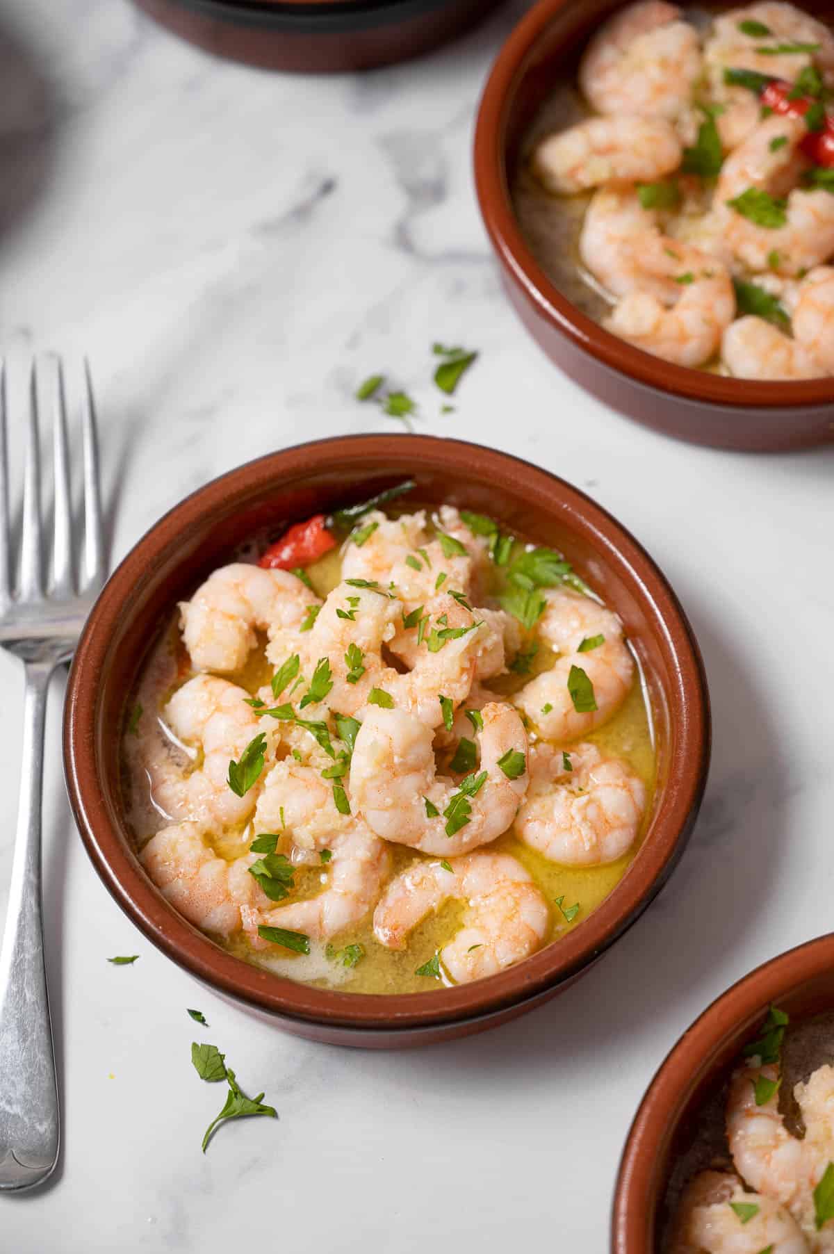 Gambas al ajillo (garlic shrimp) in small clay tapas dishes