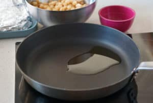 A frying pan with olive oil to prepare espinacas con garbanzos