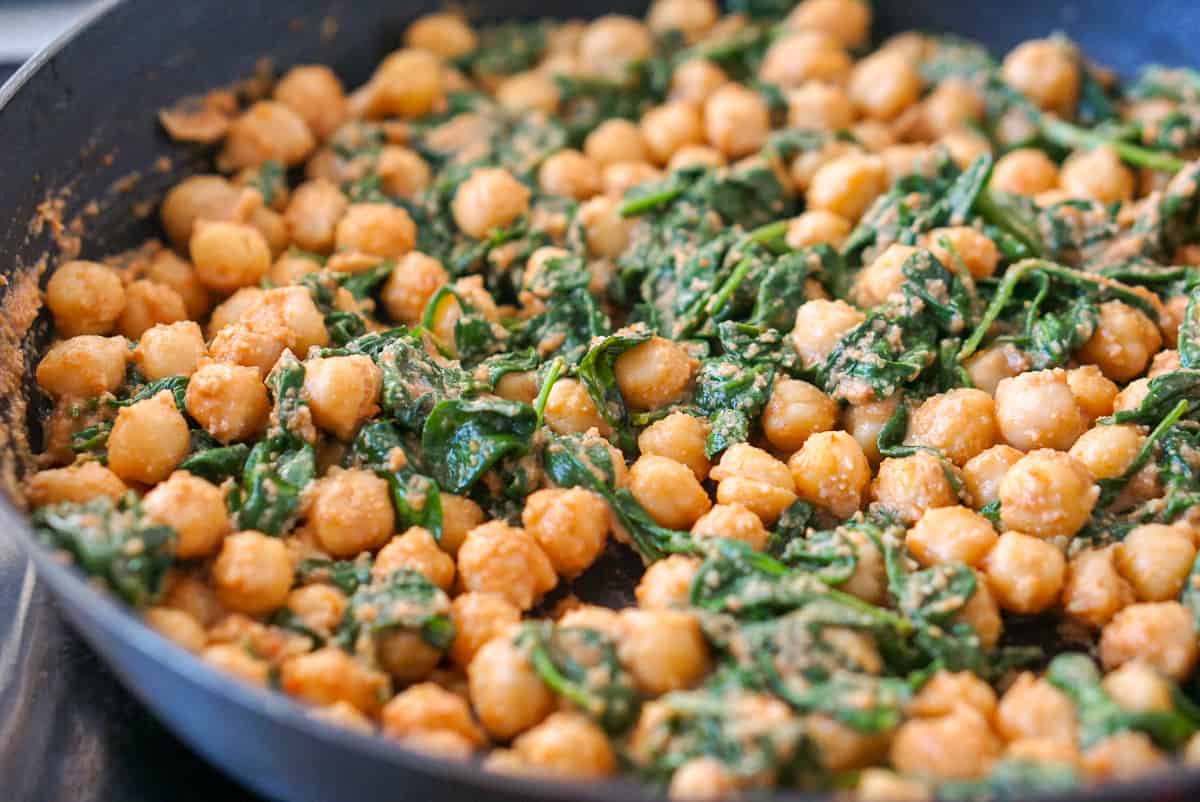 Close-up of Spanish spinach and chickpea stew in a frying pan.