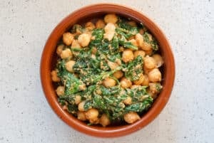 Spinach and chickpea stew in a clay dish