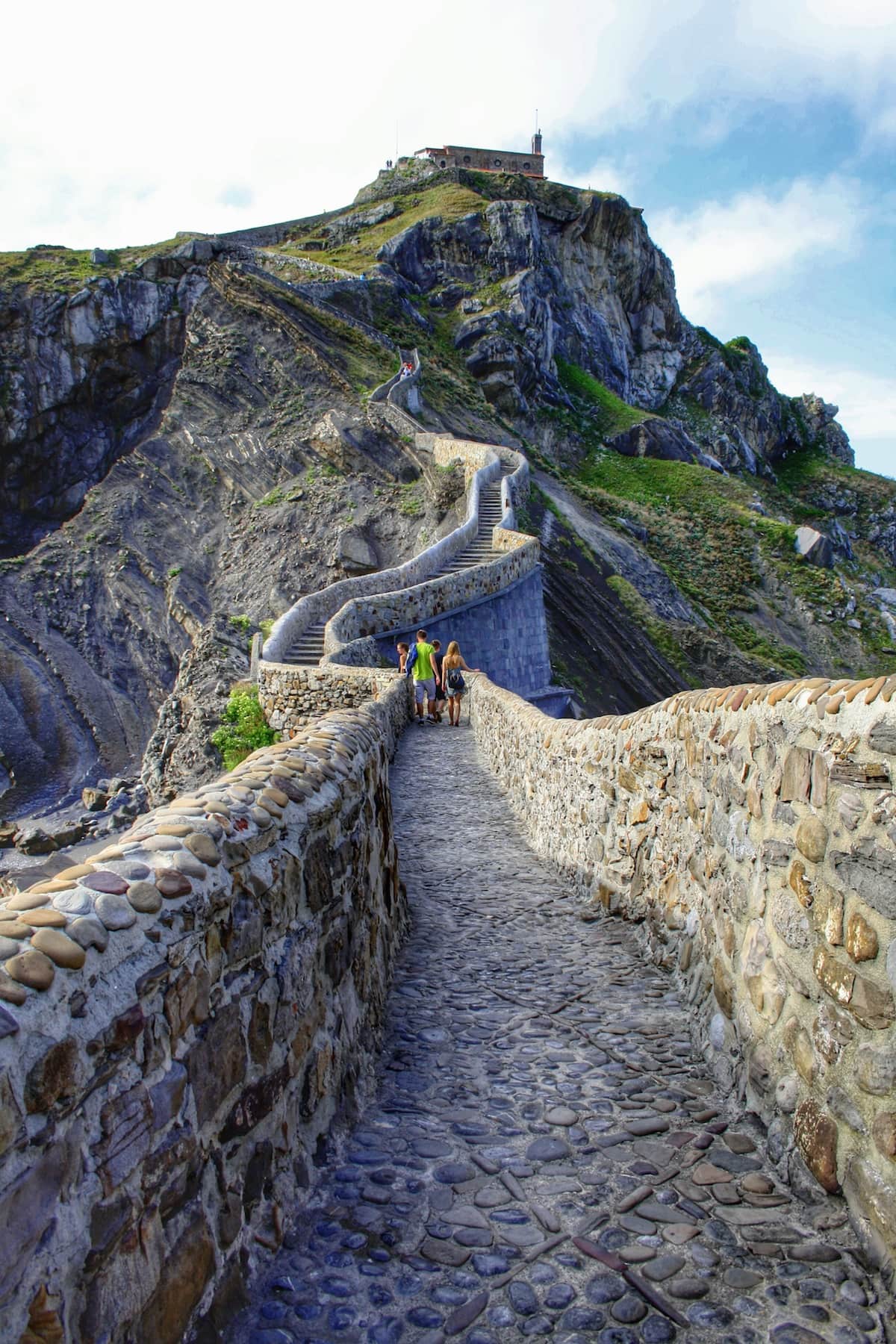 A stone path and steps leading up the side of a mountain to a small church