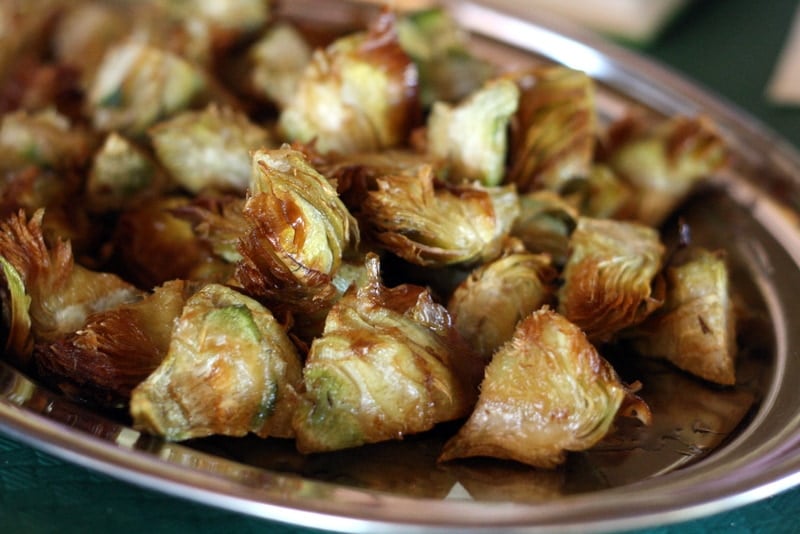 A metal platter of small pieces of  crispy and golden-brown fried artichoke.