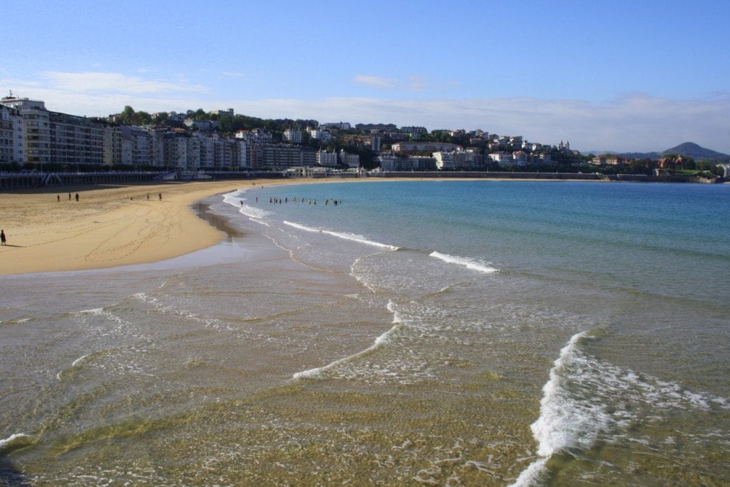 La Concha beach, a large sandy bay with buildings in the background