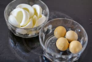 Hard boiled eggs with whites and yolks in two separate bowls