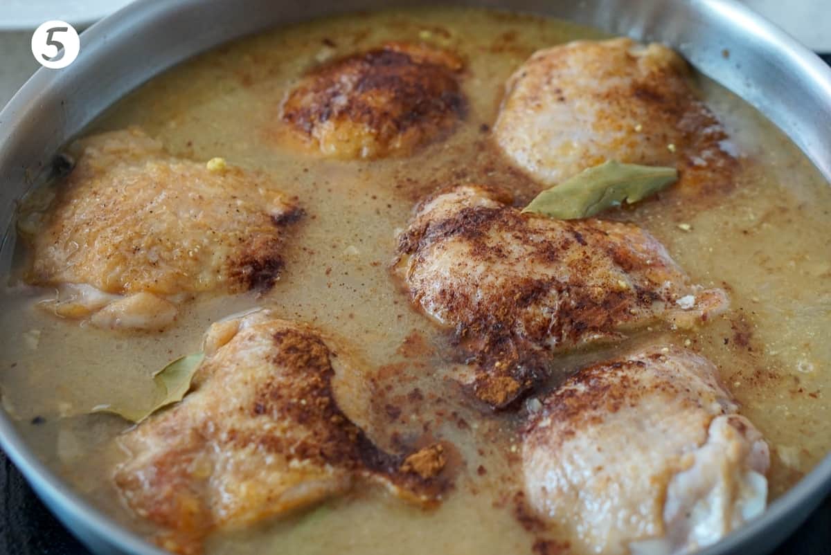 Chicken in a pan of sauce with cinnamon
