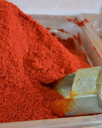 Smoked paprika sold in bulk at a spice store, with a metal scoop