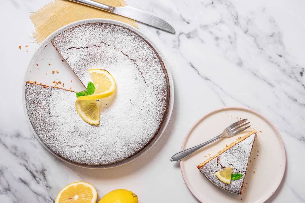 Overhead shot of lemon olive oil cake with one slice missing.