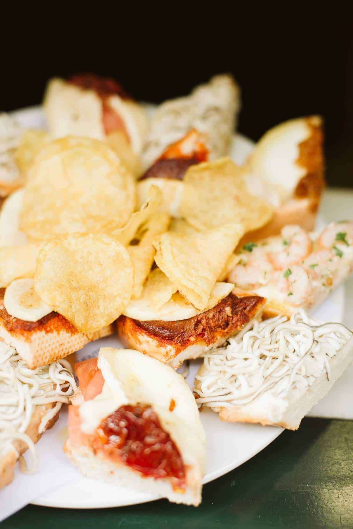 Tray of small open-faced sandwiches with potato chips in the middle