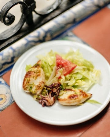 Grilled squid with salad on a white plate