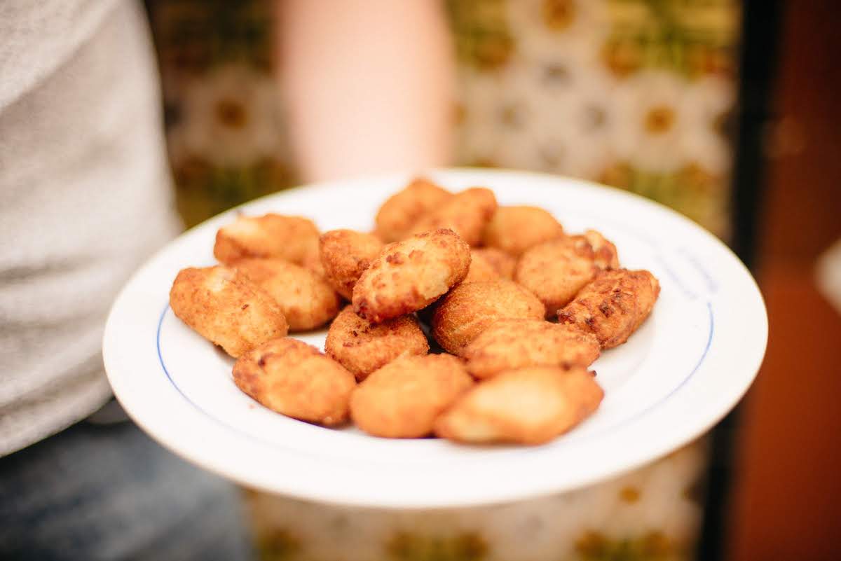 Close-up of a plate of golden brown croquettes.