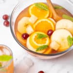Cava Sangria in a punch bowl with orange and apple slices