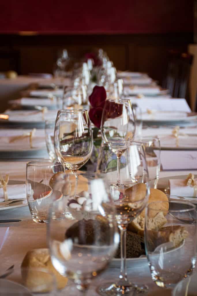 Vertical shot of a Christmas dinner table with place settings and wine glasses