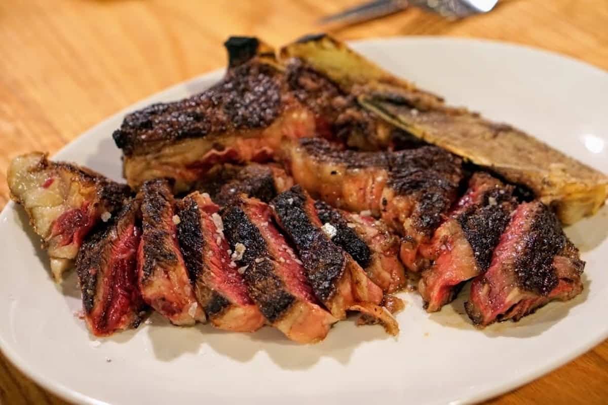 Medium rare steak on a white plate