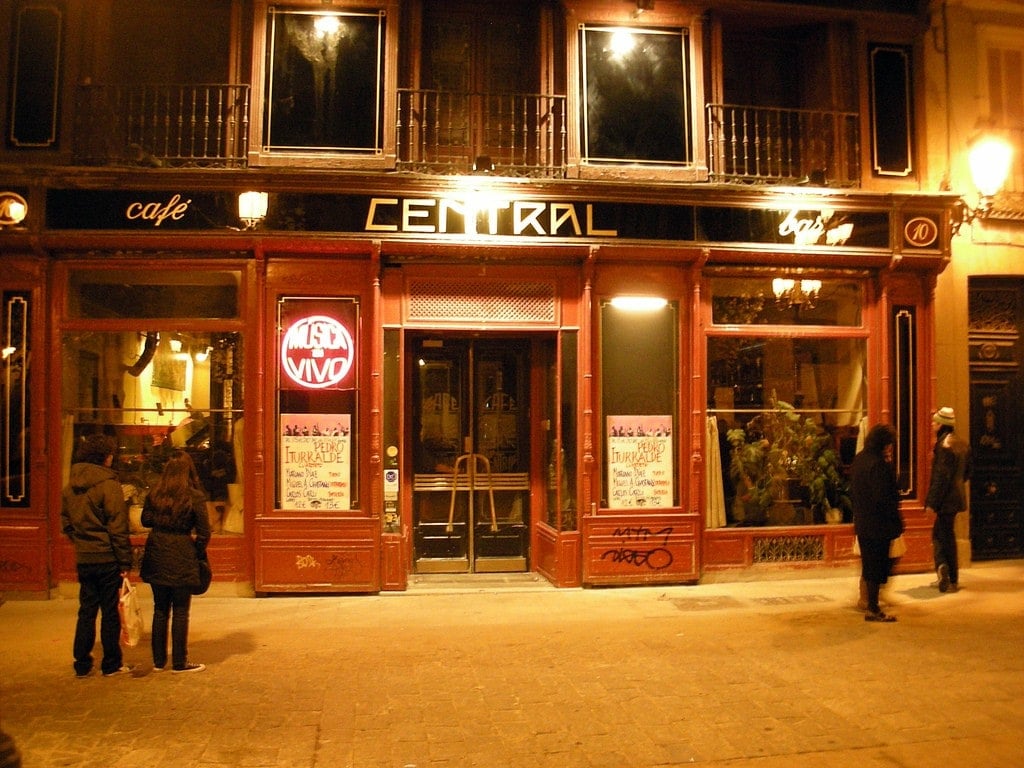 The red facade of Café Central in Huertas, lit up at night