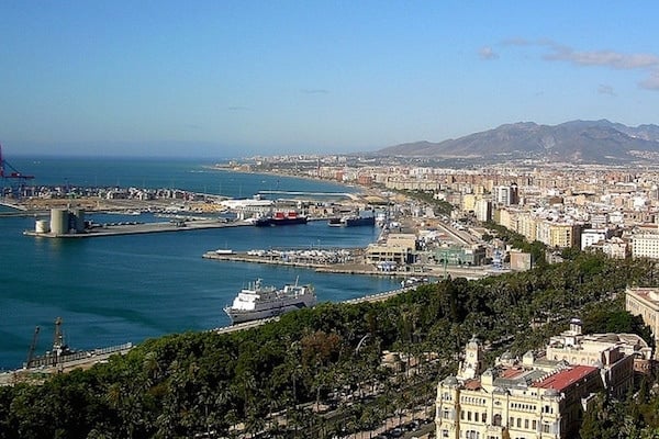 A panoramic view of Malaga and its port, with mountains in the distance.