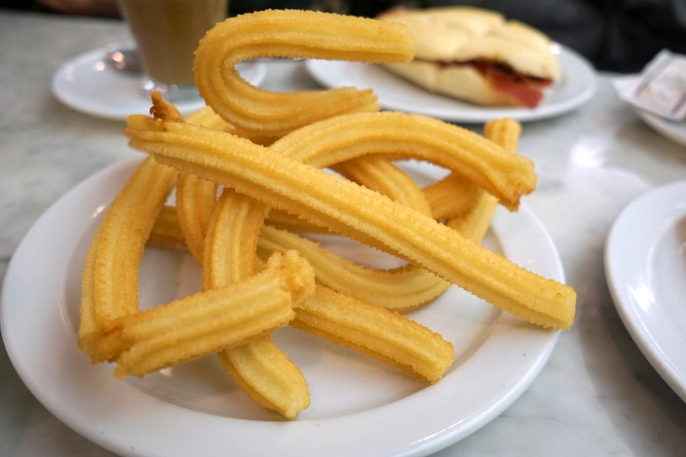 A plate of tejeringos, long and thin pieces of fried dough.