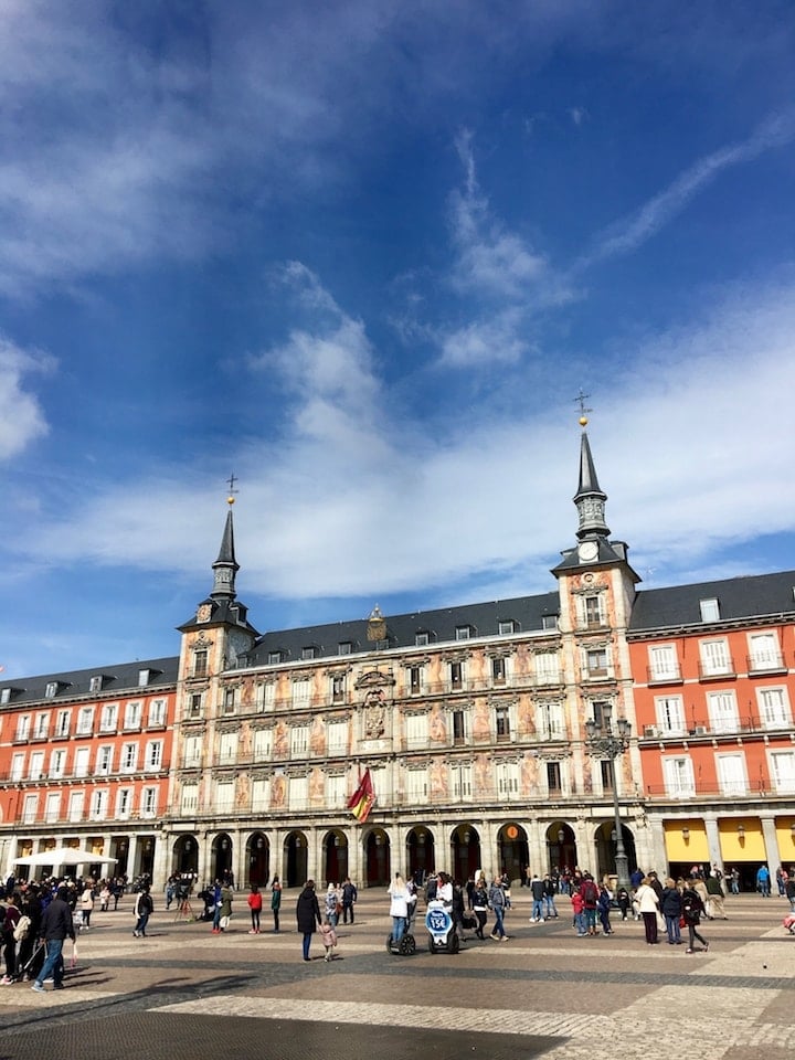 The enormous Plaza Mayor in Madrid, featuring an elaborately painted building with two tall towers.