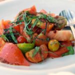 A tomato salad topped with greens—just one example of some of the fabulous vegan and vegetarian food in Santiago de Compostela!