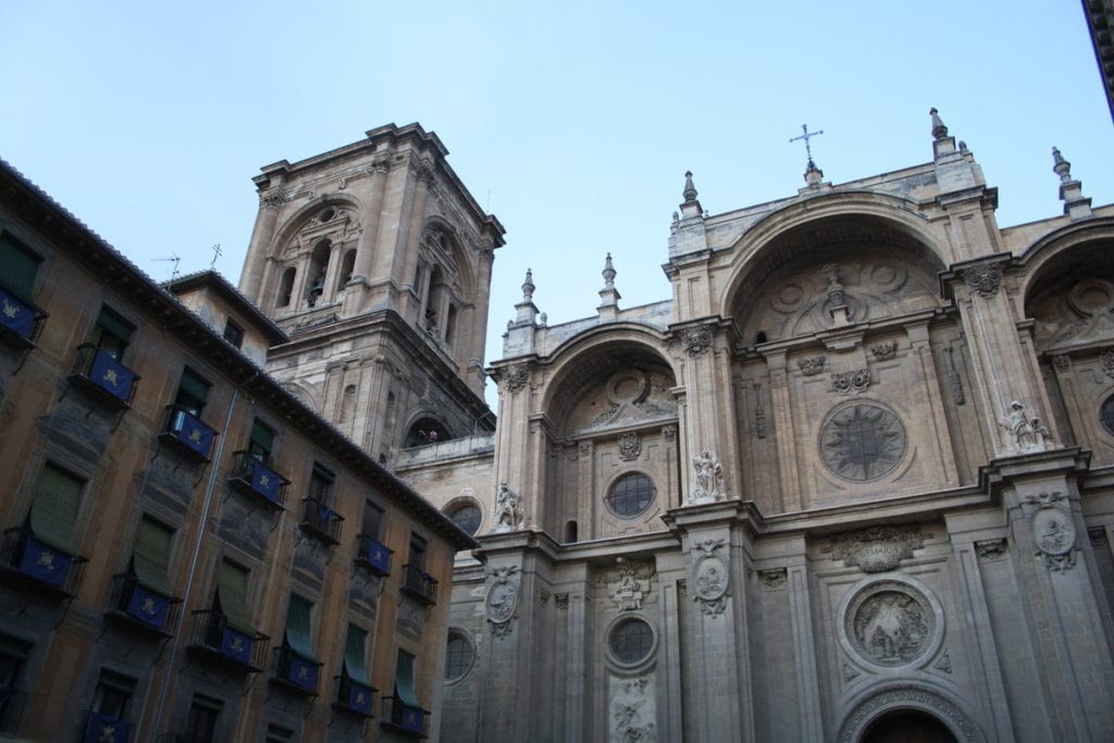 The ornate facade of the Granada Cathedral, with a bell tower in the background