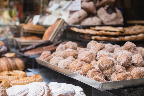 A display of buñuelos, small round pieces of sugar-covered fried dough, surrounded by other sweets.