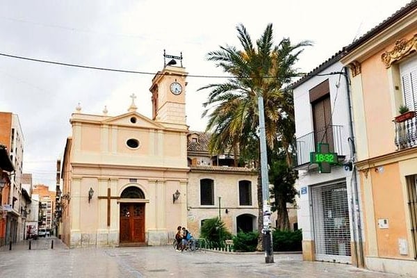 A lovely square in Benimaclet, Valencia with a small church and a palm tree