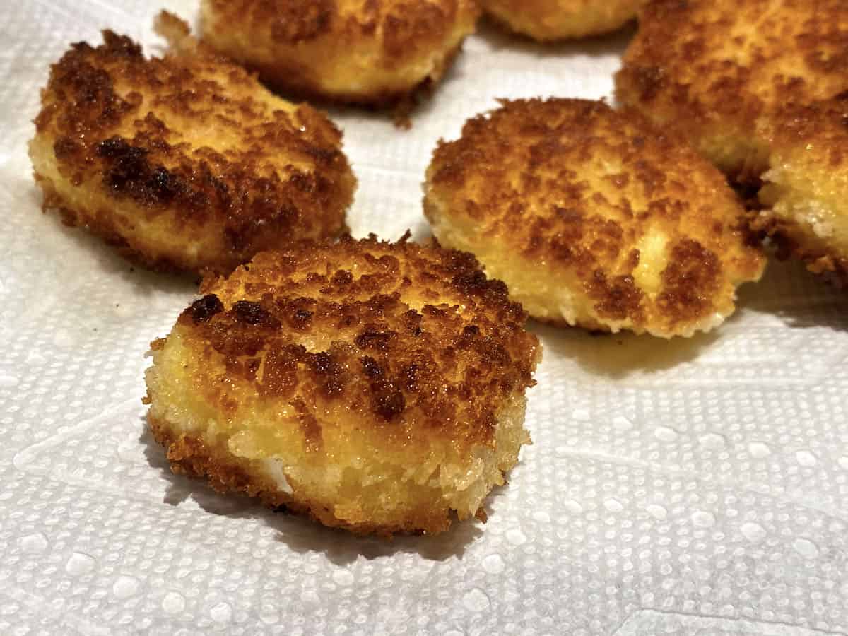 Several small pieces of golden brown fried goat cheese on a white napkin.