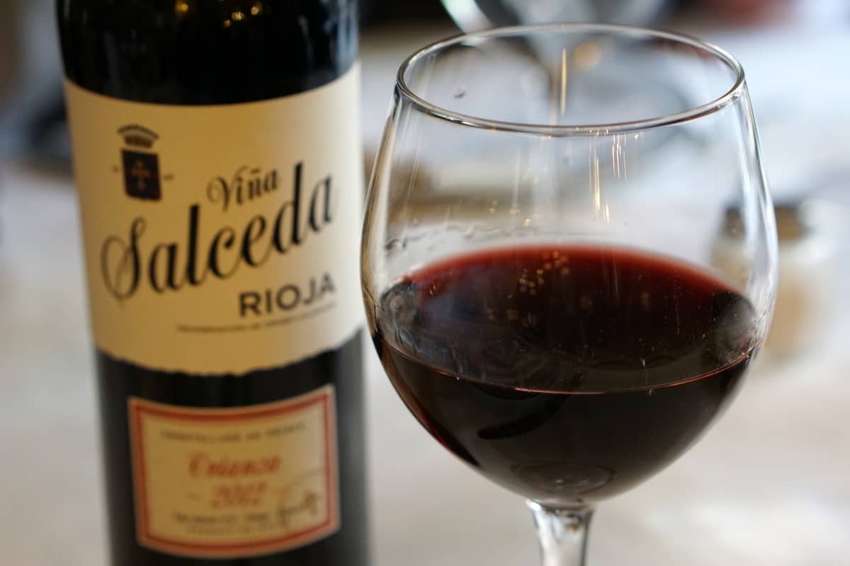 Glass of red Rioja wine next to its bottle