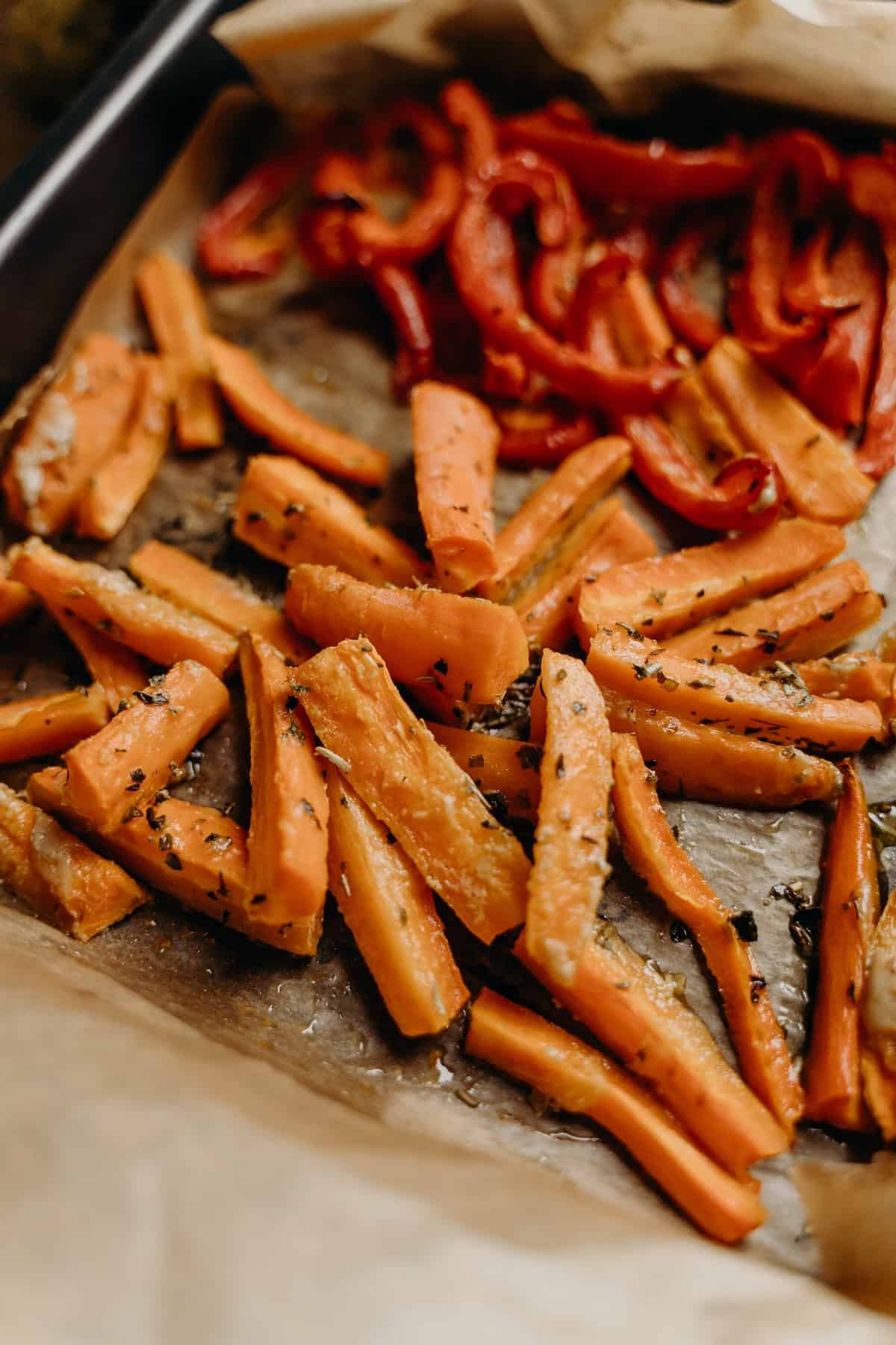 Roasted carrots with herbs and spices on a baking tray