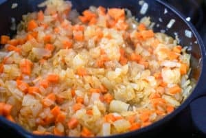Onions, carrots and garlic cooking in a skillet
