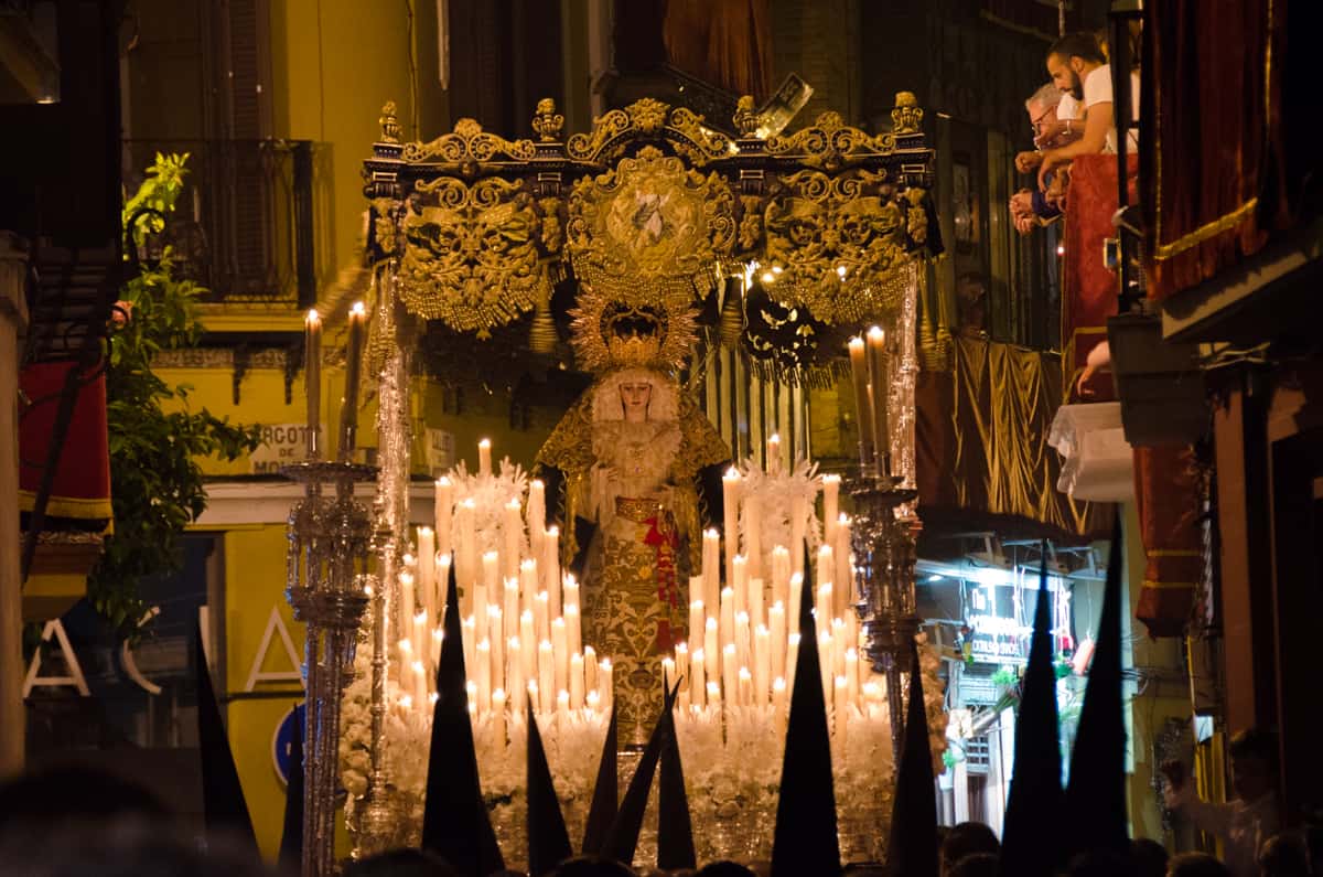 A Holy Week float covered in candles and an ornate statue of the Virgin Mary.