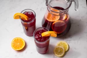 pitcher of tinto de verano with citrus fruit and two tall glasses