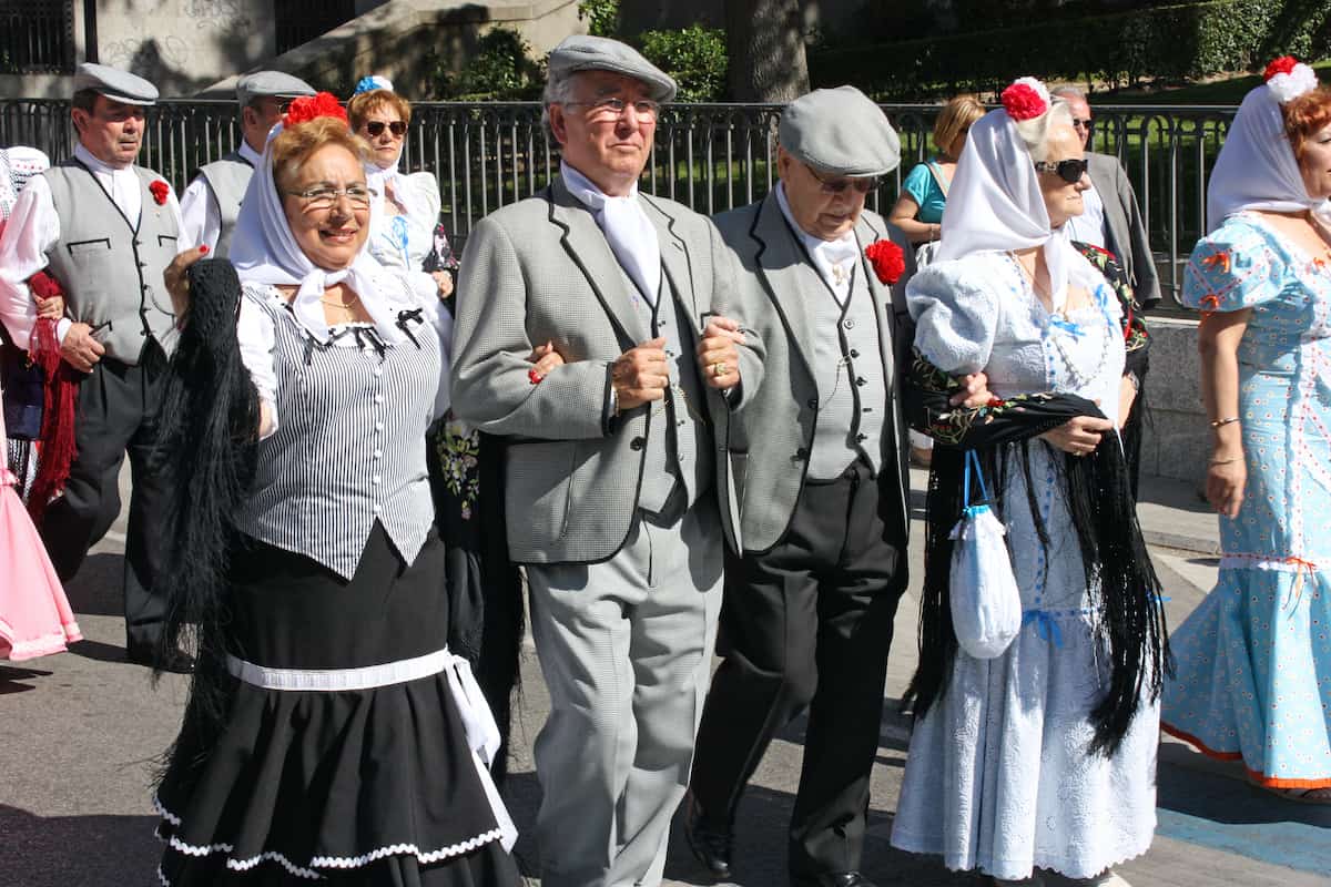 A group of older people dressed in traditional costumes from Madrid at a local festival.