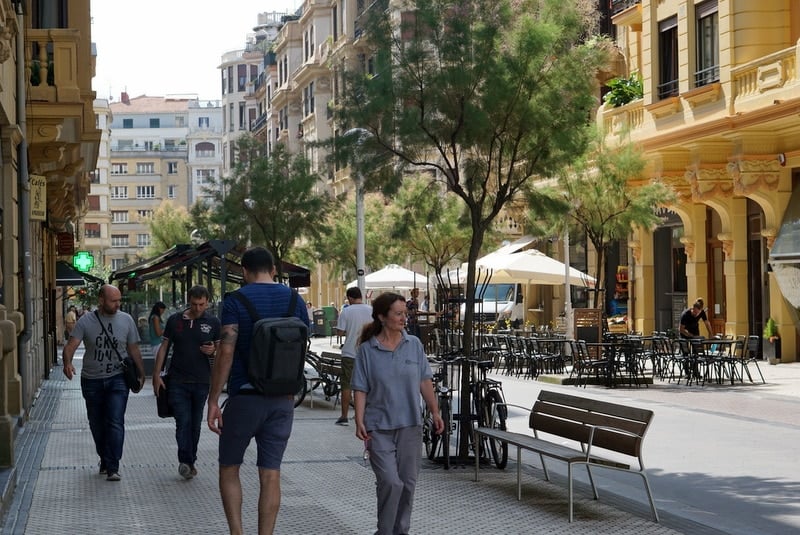 A wide street in San Sebastian lined with trees and ornate buildings 