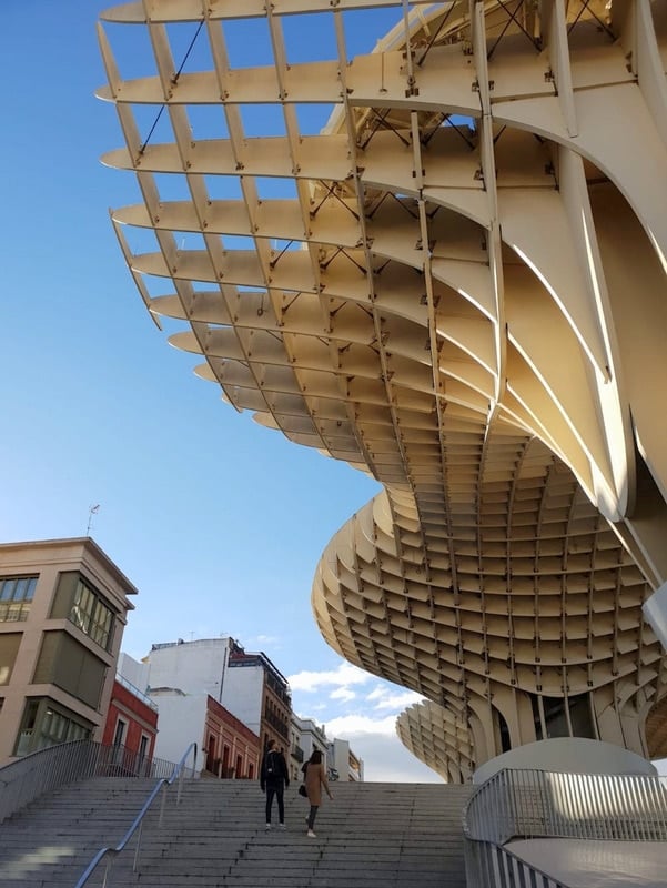 People walk up stairs beside Seville's famous wooden structure of Las Setas