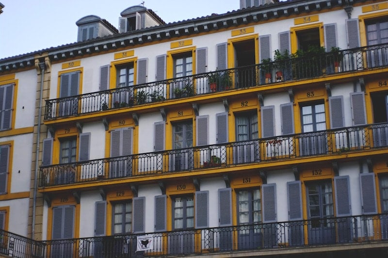 The front of a building in San Sebastian's Old Town, with balconies and yellow trim