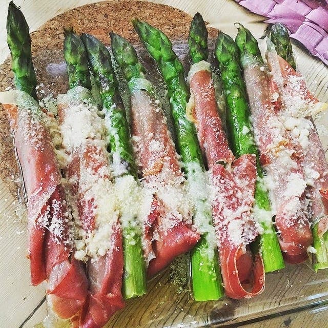 Spears of asparagus wrapped in cured ham and topped with shredded Manchego cheese.