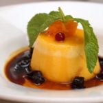 Pumpkin flan (flan de calabaza) decorated with dried fruit and a sprig of mint