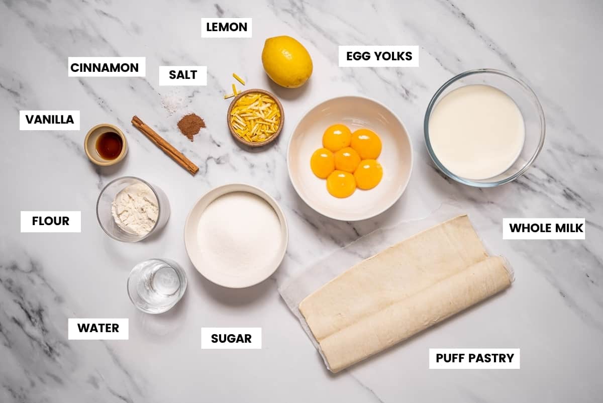 Ingredients to make pasteis de nata or custard tarts on a white marble countertop