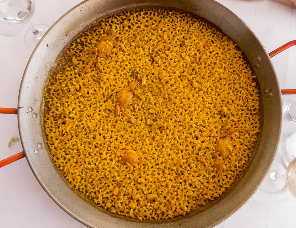 Overhead shot of a seafood rice dish in a large, wide pan.