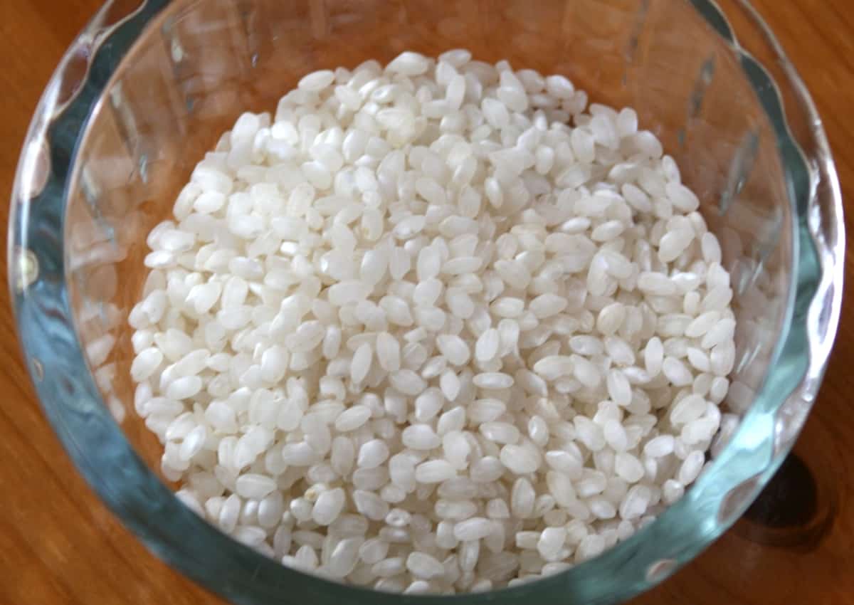 Glass bowl of uncooked short-grain rice.