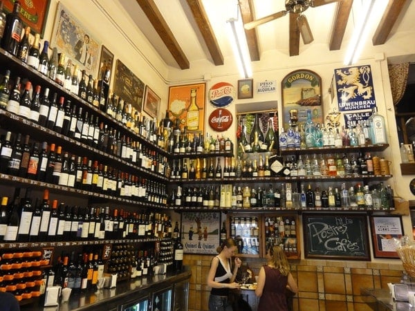 The inside of Quimet & Quimet, with bottles of wine and vintage signs covering the walls.