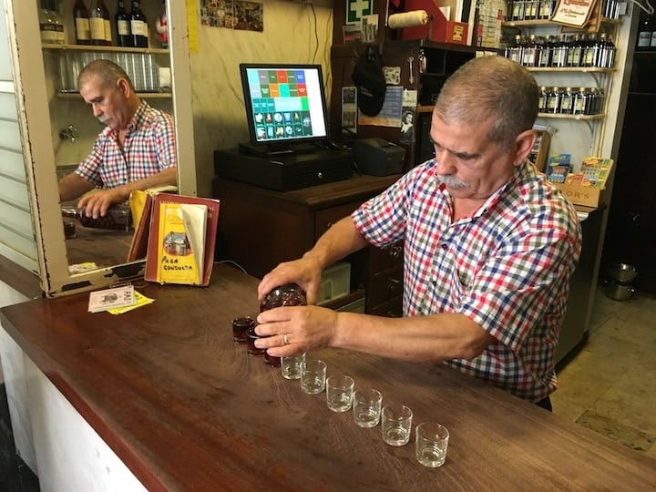 A local vendor serving ginjinha on our food tour in Lisbon.