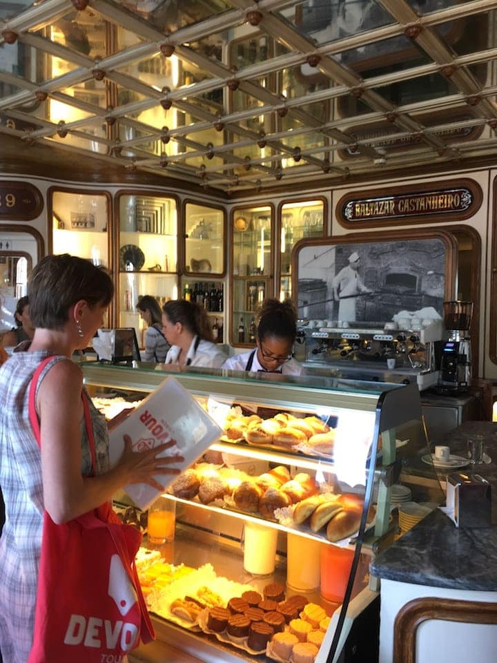 Ordering pastries and coffee on a food tour in Lisbon.