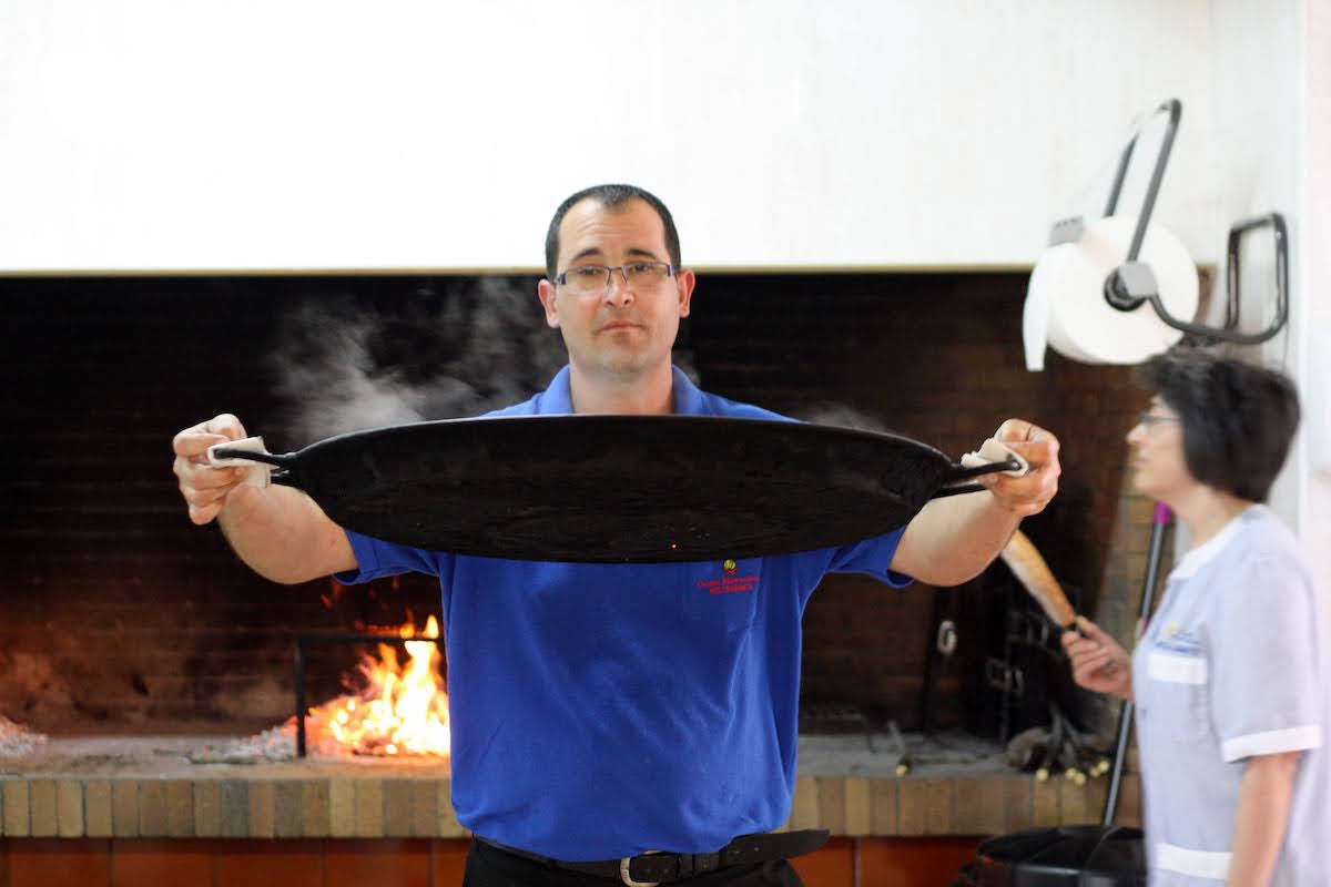 Waiter carrying a large paella.